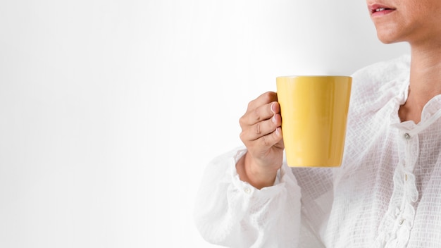 Close-up person holding a yellow cup