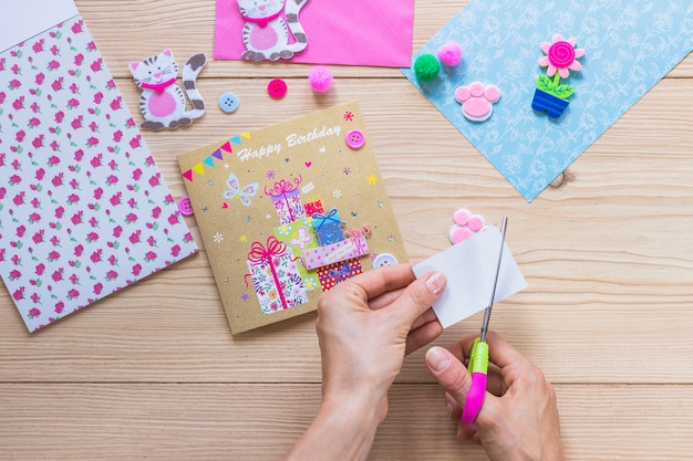 Close-up of a person making happy birthday greeting card