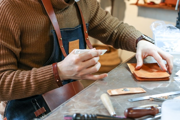 Close up of a person making leather products in the workshop