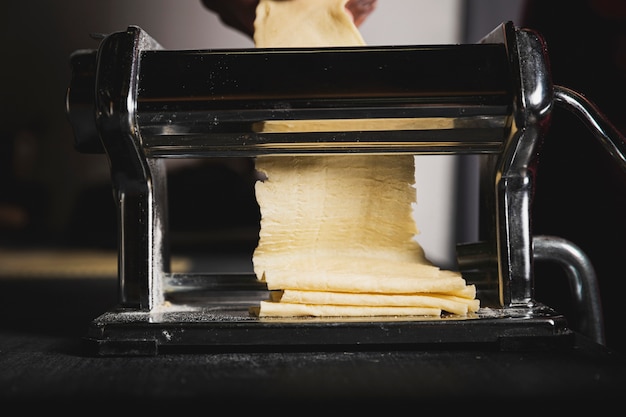 Close-up person making pasta with machine