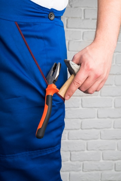 Close-up person in overalls with tools