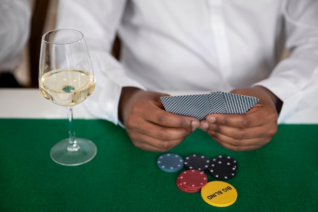 Free photo close up on person playing poker with friends