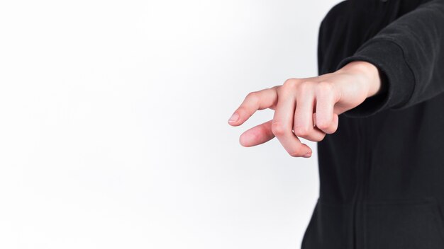 Close-up of a person pointing finger against white background
