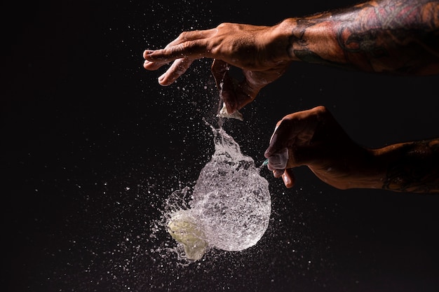 Close-up person popping a balloon