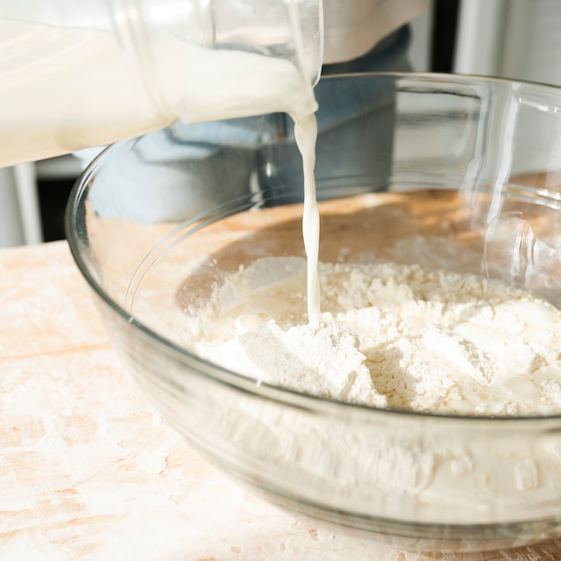 Free photo close-up person pouring milk in a bowl