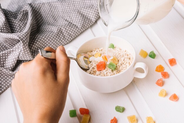 Close-up of a person pouring milk in the oatmeal