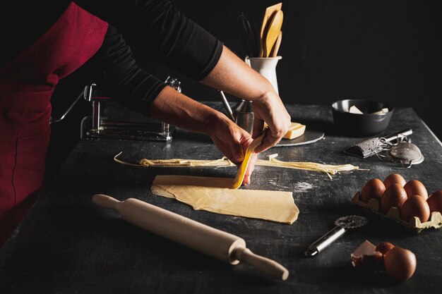 Close-up person preparing dough for pasta