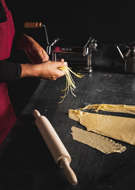 Persona del primo piano che prepara pasta