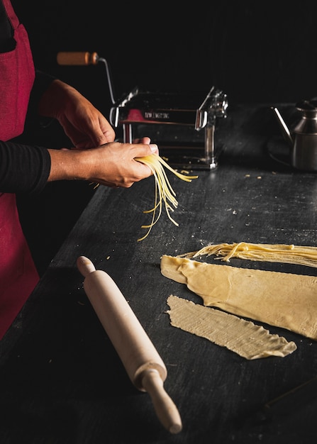 Close-up person preparing pasta 