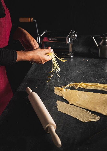 Close-up person preparing pasta 
