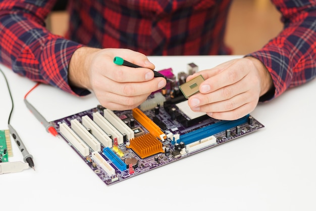 Close-up person repairing a motherboard