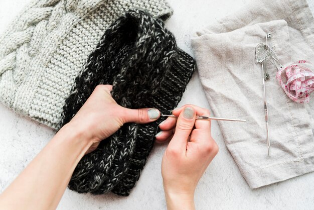 Close-up of a person's hand crocheting with wool