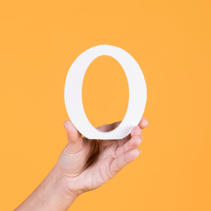 Free Photo close-up of person's hand holding capital o alphabet