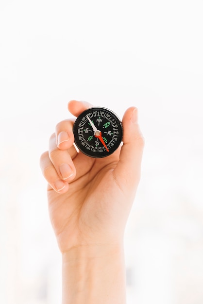 Free photo close-up of a person's hand holding compass isolated on white background