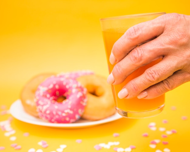 Close-up of a person's hand holding glass of juice