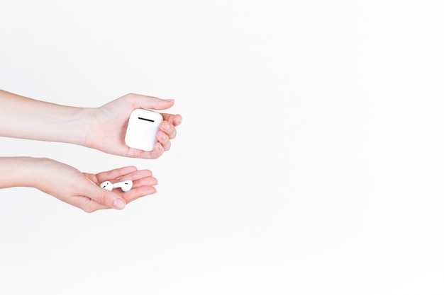 Close-up of a person's hand holding hearing aid and battery