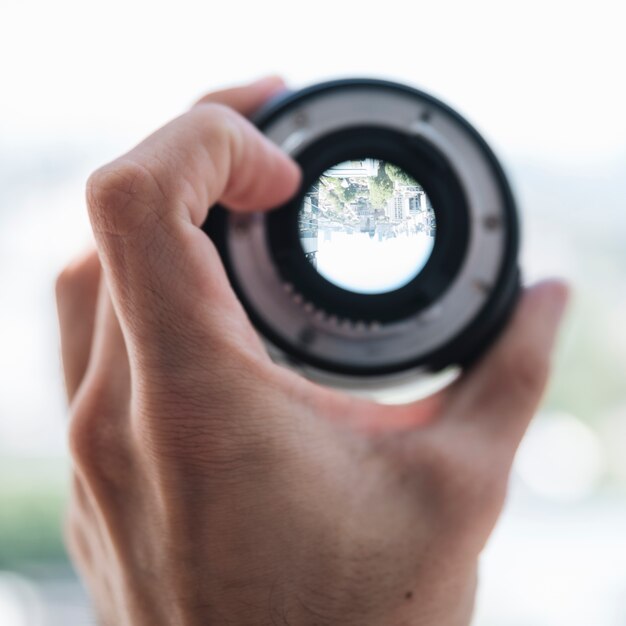 Close-up of a person's hand showing city view through the digital lens