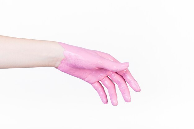 흰색 배경 위에 분홍색 페인트로 사람의 손 클로즈업