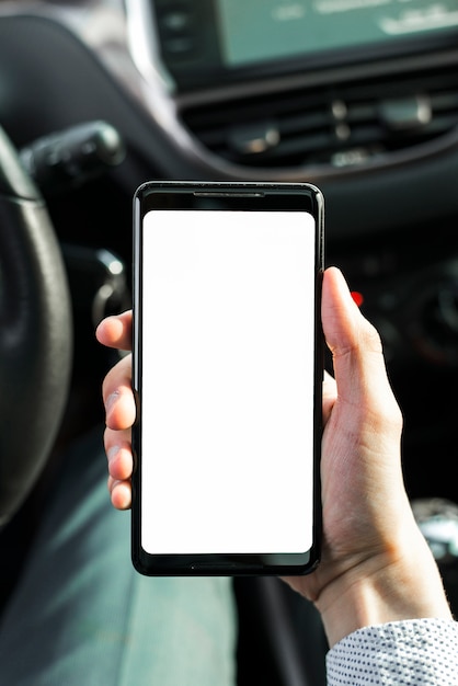 Close-up of a person showing mobile phone in the car