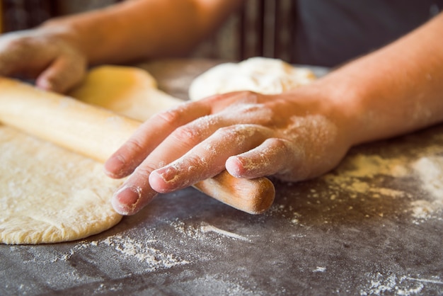 Close up person spreading dough