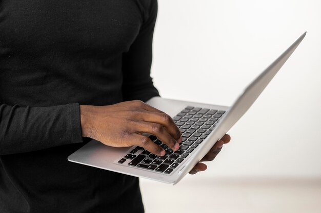 Close-up person standing and using a laptop