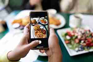 Free photo close up on person taking photo of food