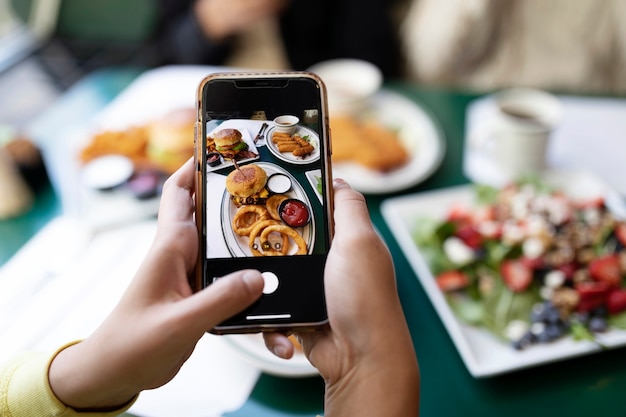 食べ物の写真を撮っている人のクローズアップ