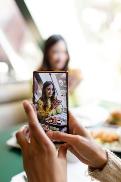 食べ物の写真を撮っている人のクローズアップ