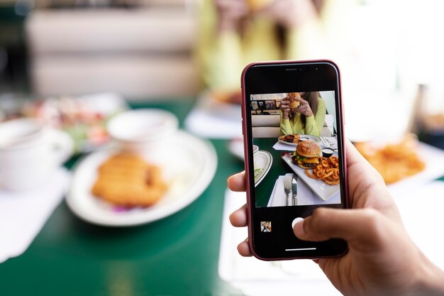 食べ物の写真を撮っている人のクローズアップ