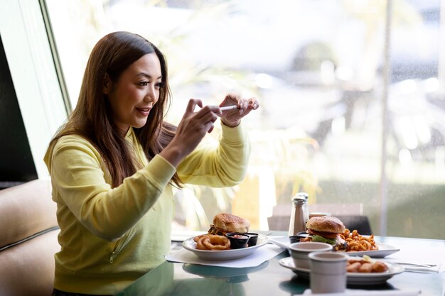 食べ物の写真を撮っている人のクローズアップ