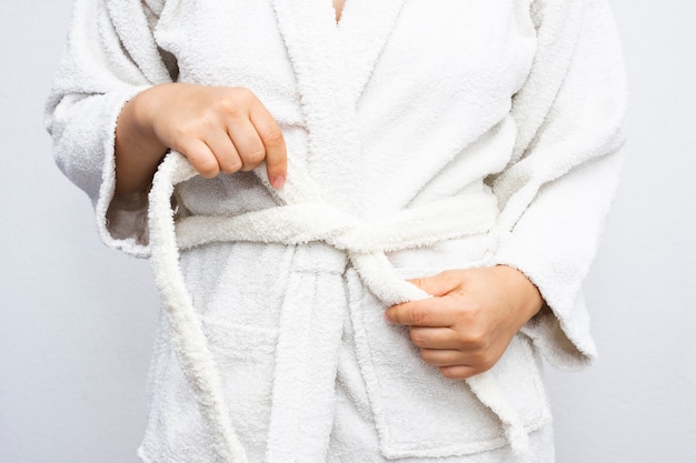 Close-up person tying bathrobe 