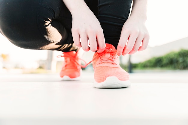 Close-up person tying laces