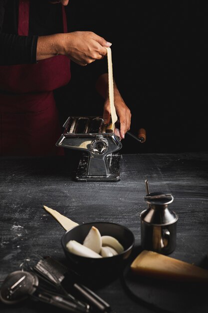 Close-up person using machine to make pasta 