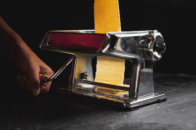 Close-up person using machine for pastry 