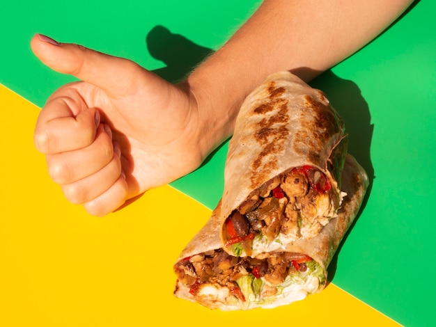 Close-up person with burrito showing approval