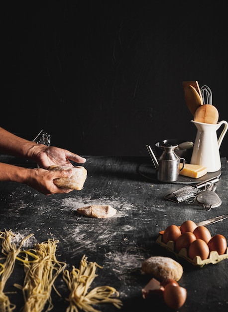 Close-up person with dough and dark background