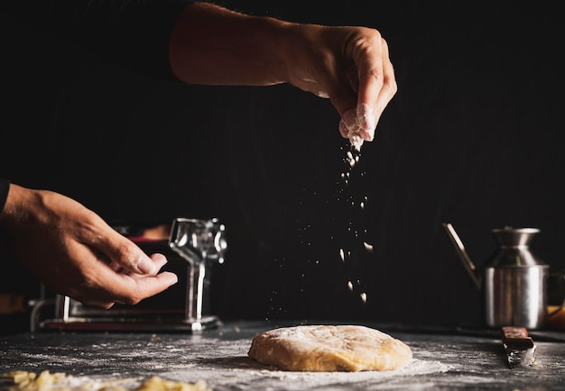 Close-up person with dough and dark background