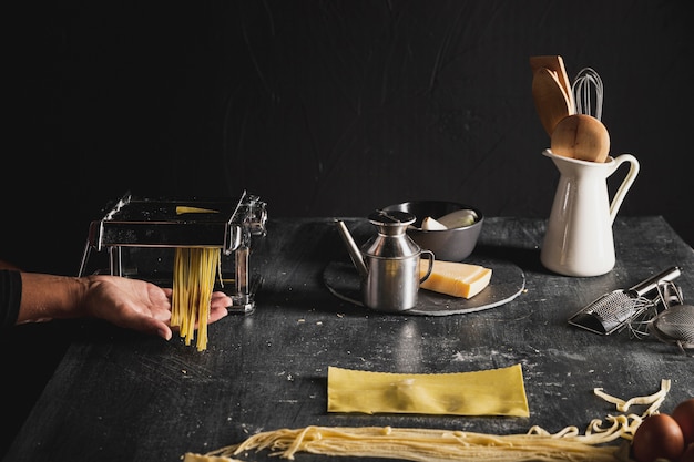 Close-up person with kitchen utensils and dark background