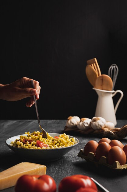 Close-up person with pasta and eggs