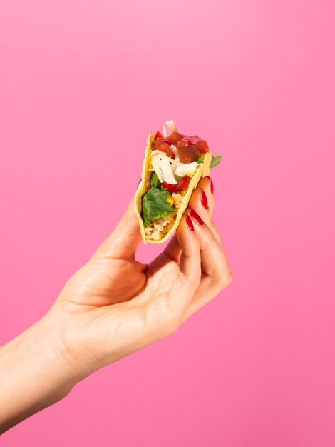 Close-up person with taco and pink background