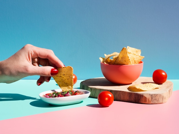 Close-up person with tortilla chips and sauce