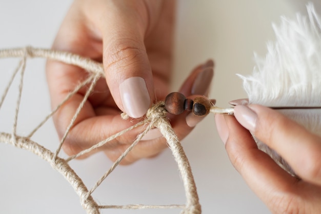 Close up on person working on dreamcatcher