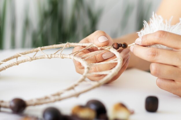 Close up on person working on dreamcatcher