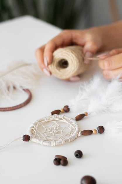 Free photo close up on person working on dreamcatcher