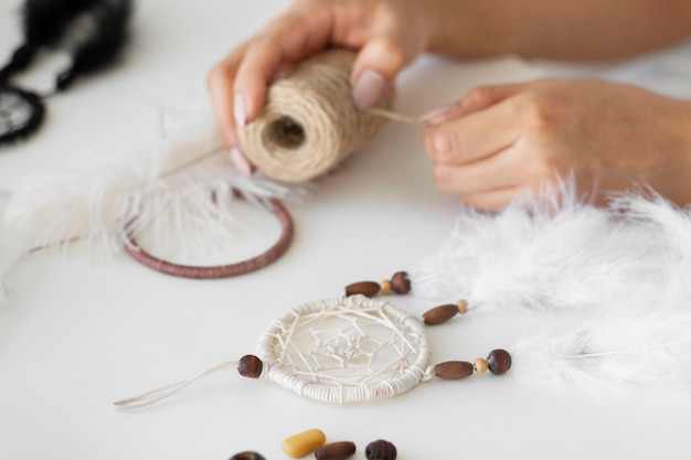 Close up on person working on dreamcatcher