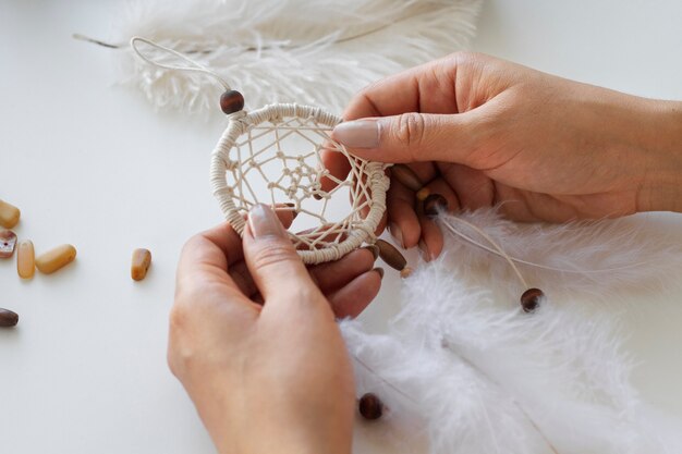 Close up on person working on dreamcatcher