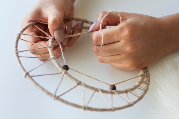 Close up on person working on dreamcatcher