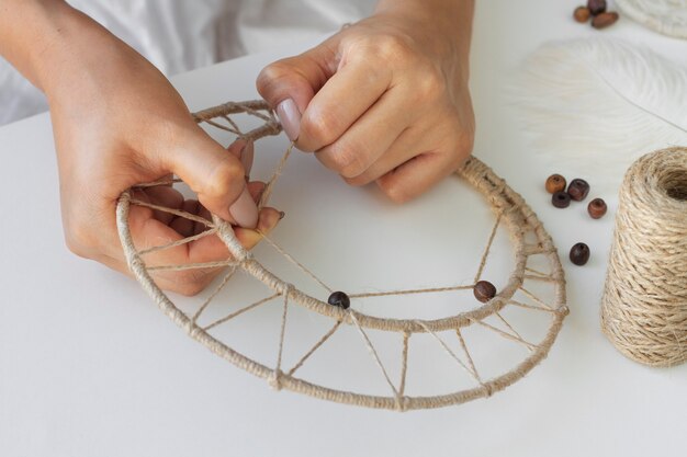 Close up on person working on dreamcatcher