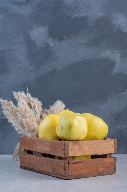 Close up photo of apple quince in wooden basket. 