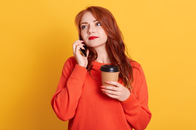 Close up photo beautiful lady open, holding hot beverage in paper container isolated, talking to phone